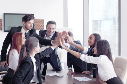 salariés autour d'une table qui font un high five